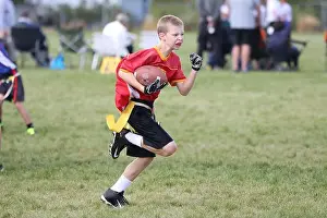 Competing Prints: Youth flag football game action shot of player running with the football attempting to score a touchdown