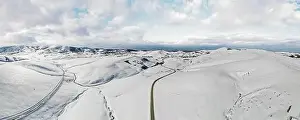 Panorama Mountain Prints: Zlatibor mountain in winter. Beautiful aerial rural landscape with curving road and hills in winter